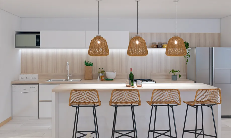 render de la cocina de frente dónde se ve una mesada en primer plano con cuatro banquetas y tres lámparas colgantes arriba. al fondo se ve la alacena junto con una heladera, un espacio de guardado y un horno. 